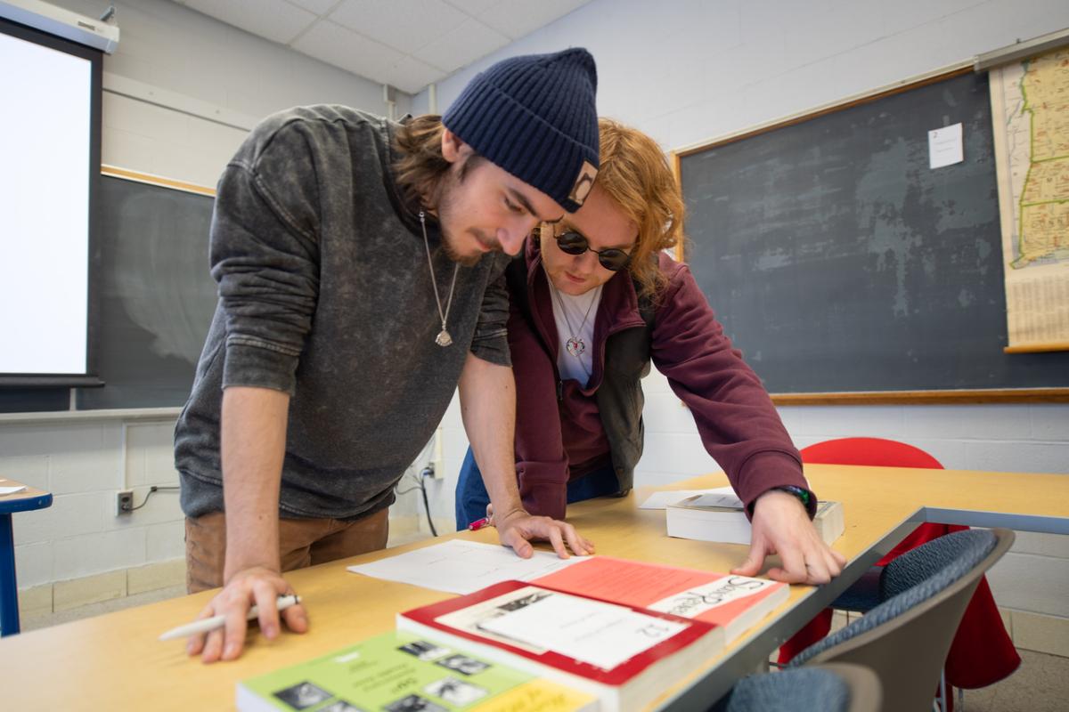 Two students in a classroom working together on a project.
