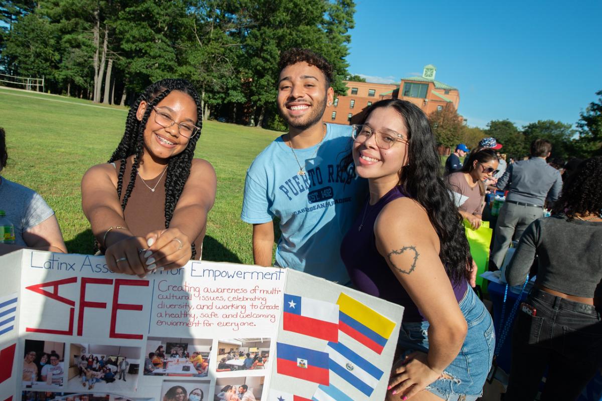 Students smiling at club fair on campus.