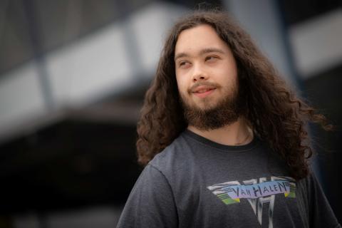 Nathan Hutnak smiling on campus with head tilted to the side.