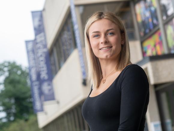 Graduate student smiling outside of Horace Mann Center