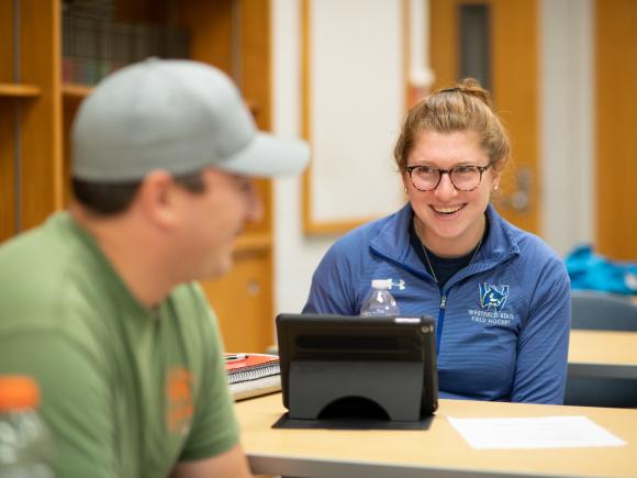 Student smiling with laptop in Public Administration course