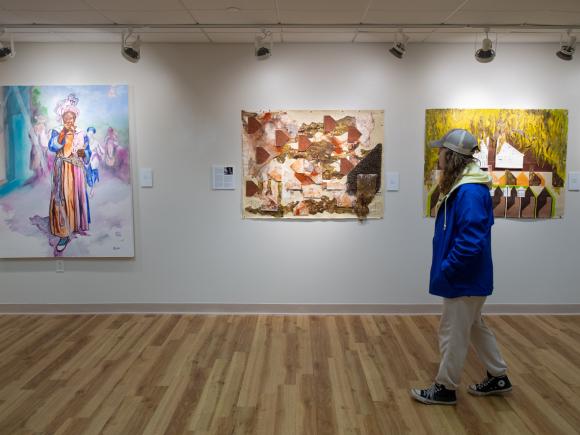 Student in Arno Maris Gallery on campus looking at artwork.