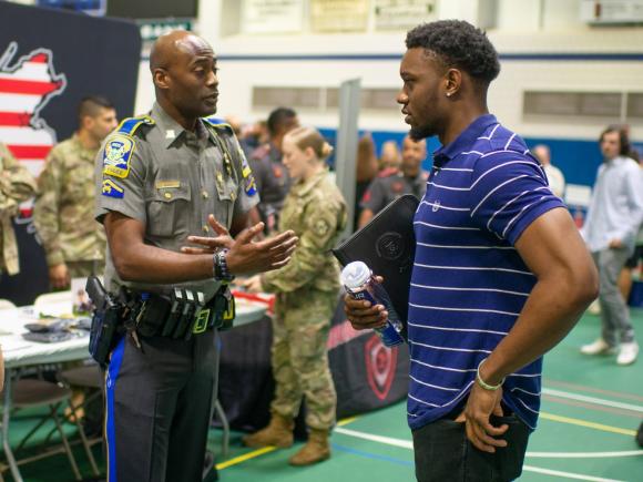 Criminal Justice student at career fair speaking with an employer.