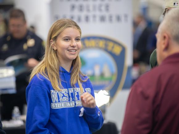 Criminal justice student at career fair speaking with an employer.