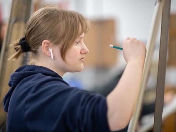 Art student drawing in a classroom.