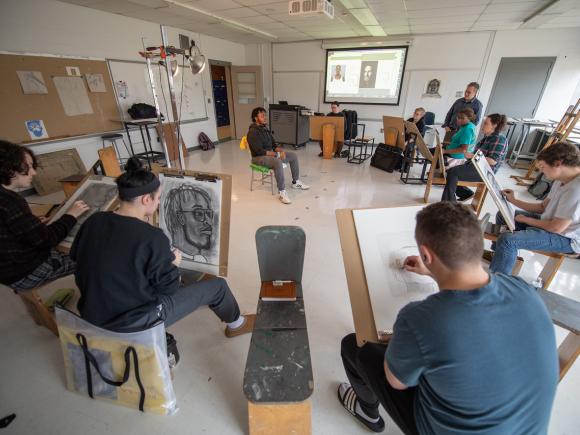 Students in an art class figurative drawing in a circle.