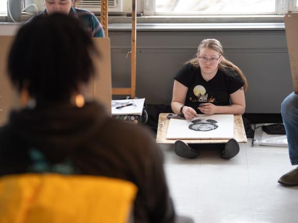 Student in an art class working on a drawing.