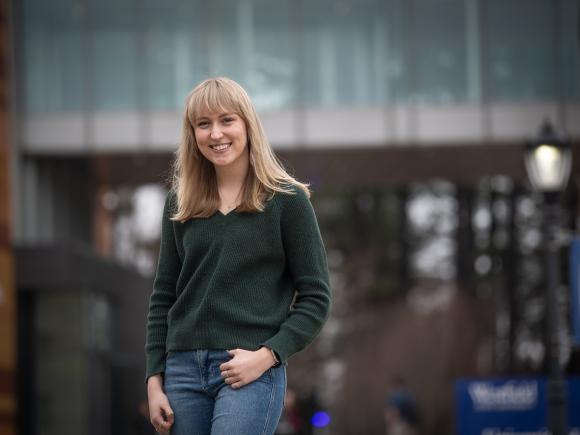 Urban and Regional Planning student smiling while standing on the campus green.