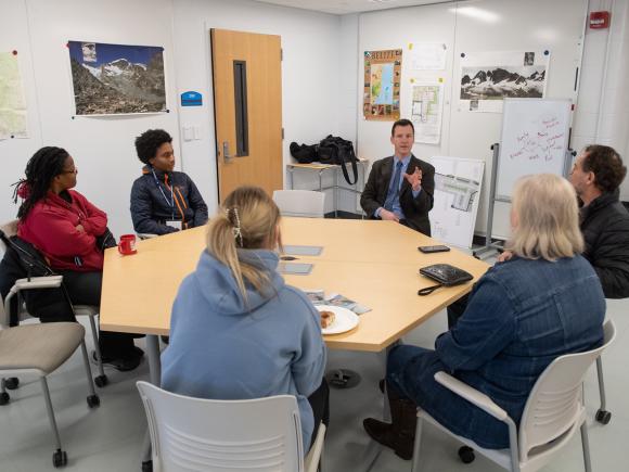 Faculty member engaged in a round table discussion with students.