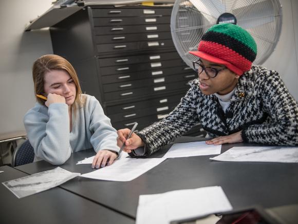 Two Urban and Regional Planning students work on a project together.