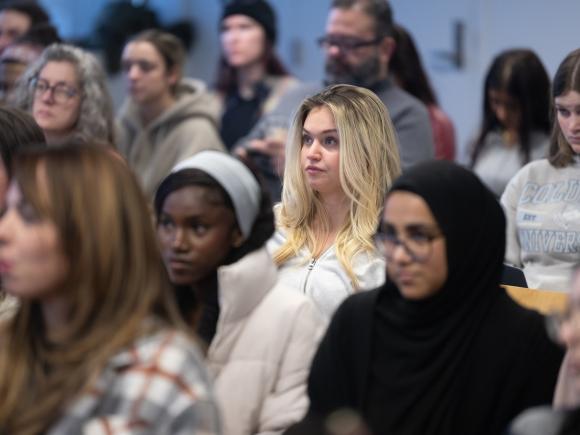 An Alzheimer's Association speaker presents to a group of students seated in rows, attentively listening.