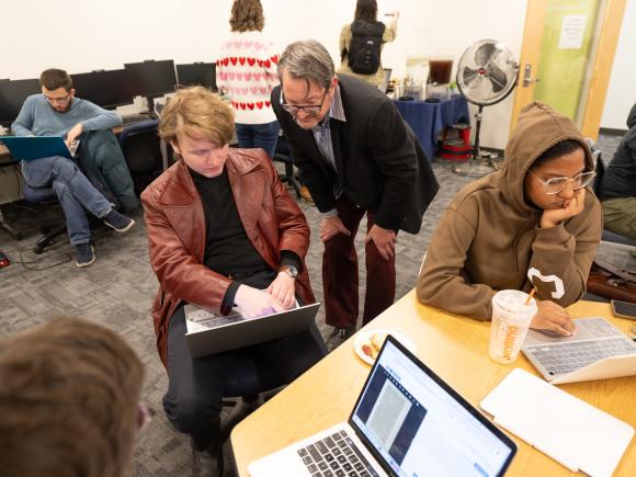 Student engaging in a classroom activity with guidance from a faculty member.