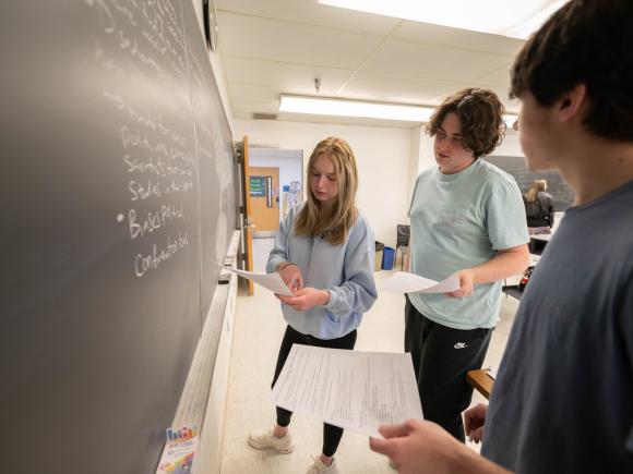 Students collaborating on a math project, discussing ideas and solving problems together.