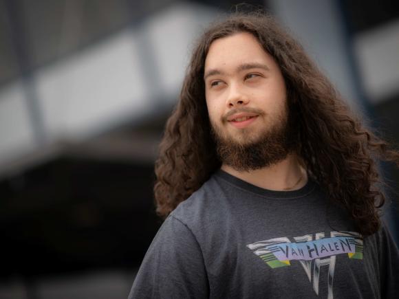 Nathan Hutnak smiling on campus with head tilted to the side.