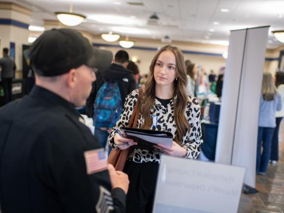 Student talking to an employer at a job and career fair.