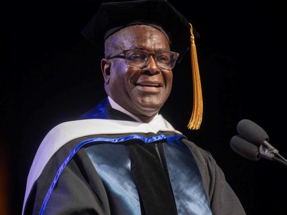 Man speaks at podium Commencement 2025