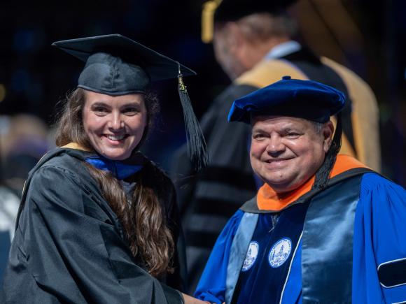 Man shakes hand of graduate Commencement 2025