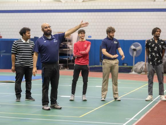 Movement Science instructor guiding students during a physical education class in the gym.