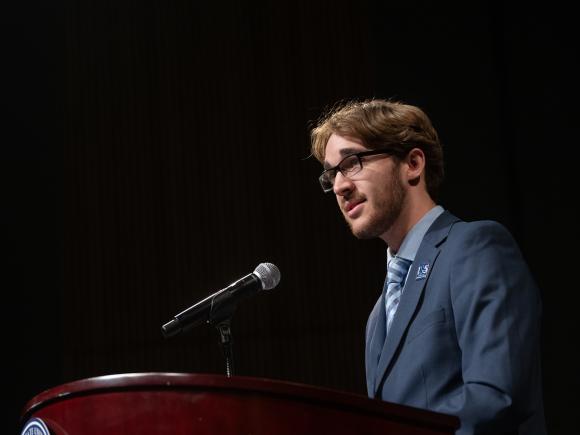 Political science student delivering a speech at a podium.