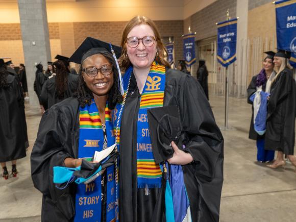 MPA students smiling and celebrating at graduation, wearing caps and gowns.