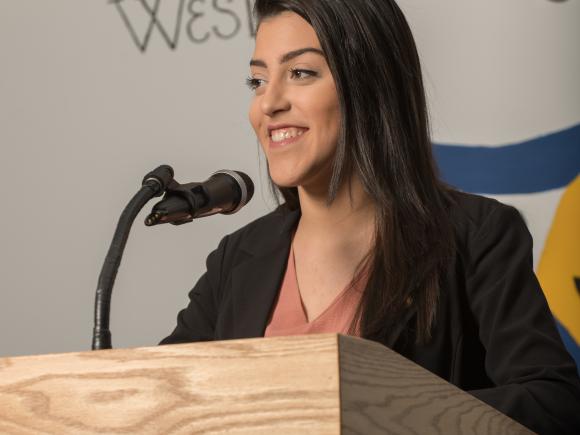 Thalita Neves speaks at a podium during a Westfield State University Student Government Association event.