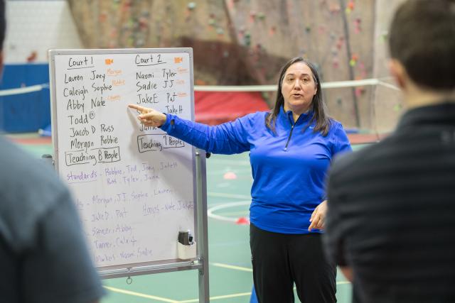 Athletic training faculty member wearing blue long sleeve shirt in gym