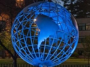 Campus globe with blue spotlight on it.