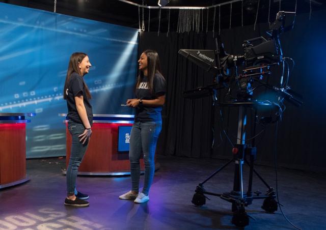 Two students on the set for As Schools Match Wits in the campus TV studio.