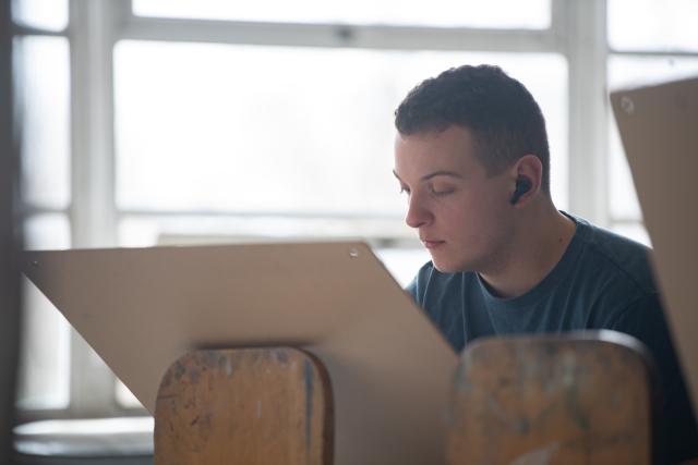 Art student working on a painting in a Dower Center Studio.