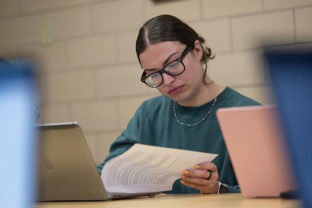 Student in a Forensic Psychology class reviewing notes during lecture.