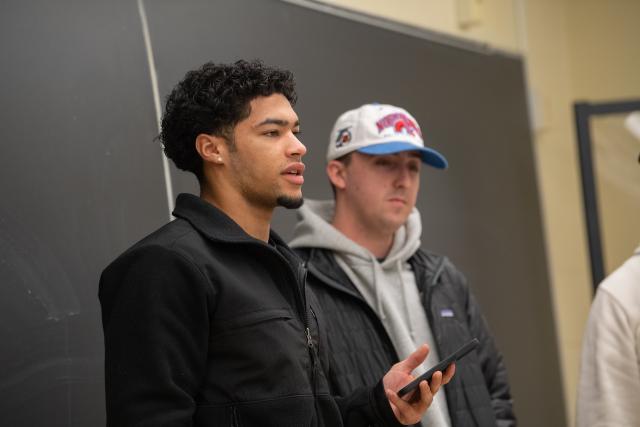 Students giving a presentation at the front of a management classroom.