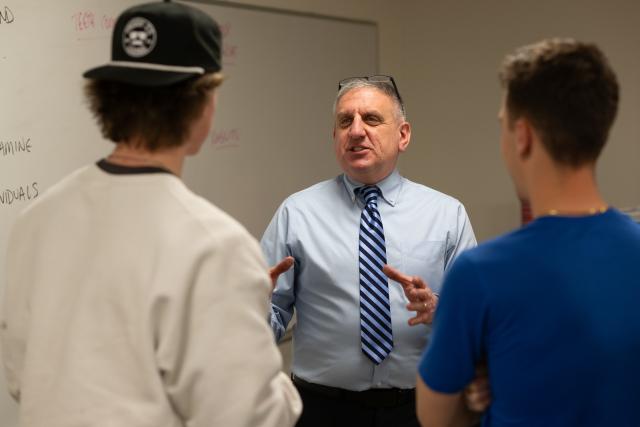Movement Science faculty member in conversation with two students.