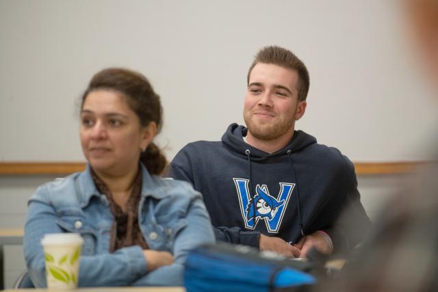 MPA student smiling in the classroom listening to the instructor.