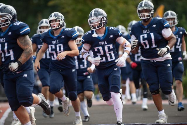 Westfield State football players sprinting down the field during a game.