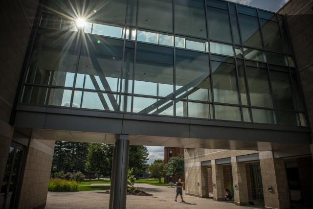 New Hall signature glass bridge with sun rays shining through it.