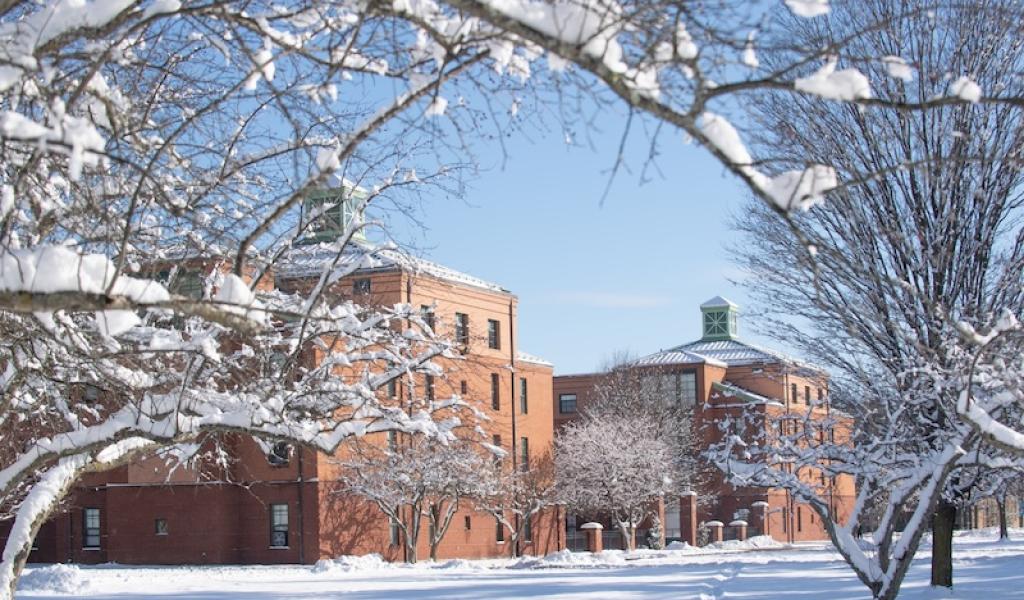 Campus with snow covering the ground and trees around it.