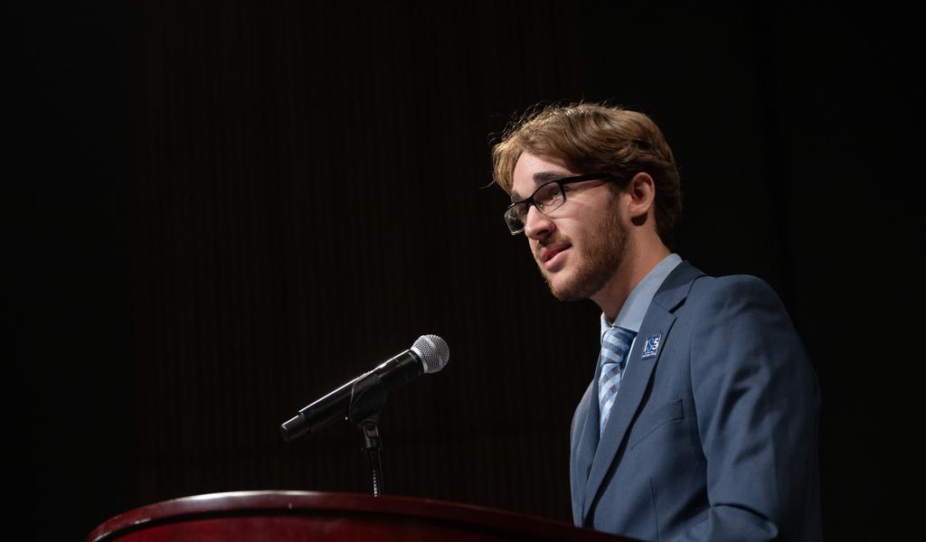 Political science student delivering a speech at a podium.