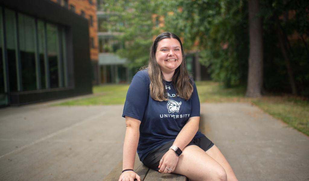 Commuter student smiling on campus wearing WSU shirt.